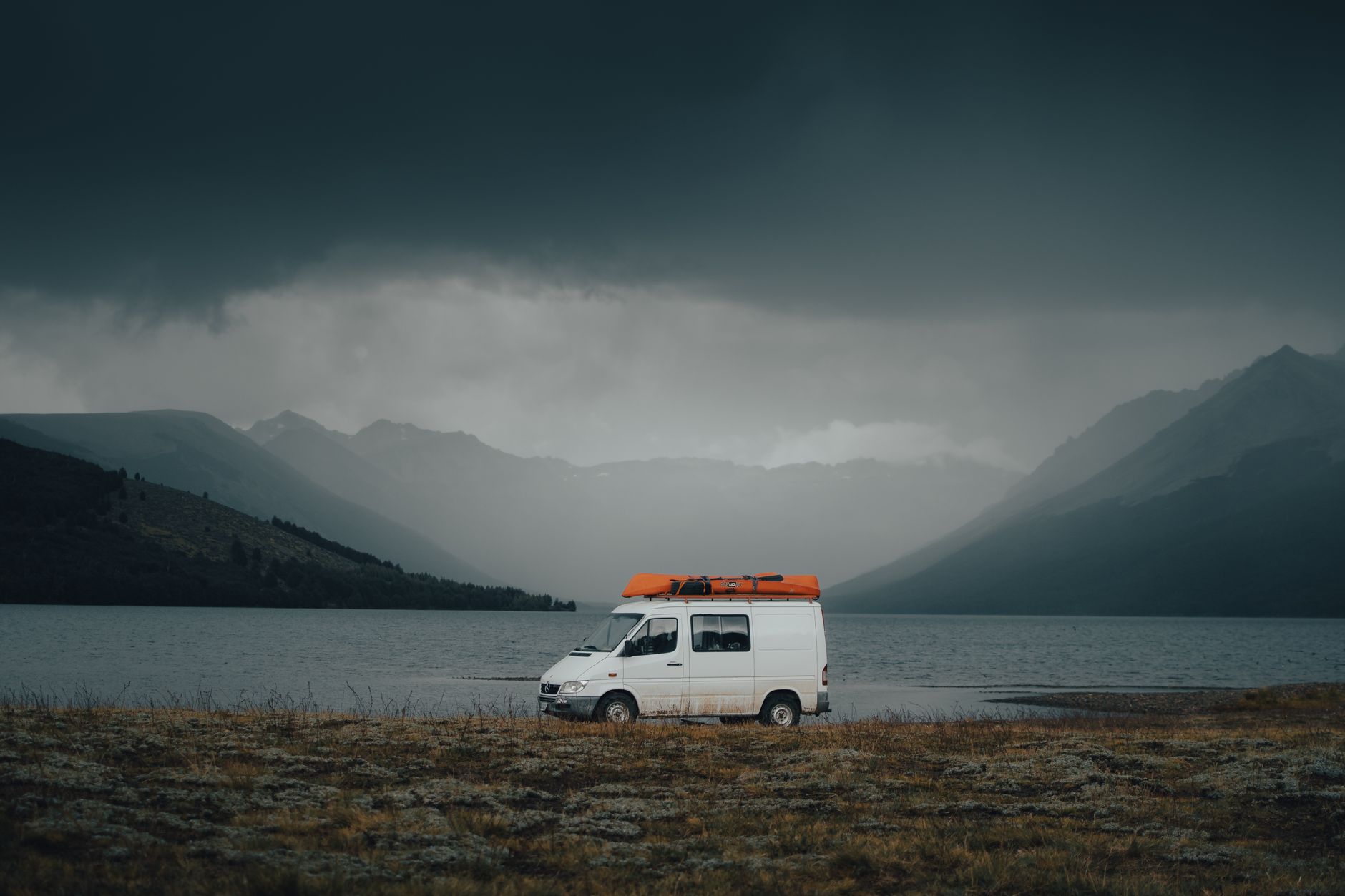 Campervan parked next to turquoise alpine lake in New Zealand